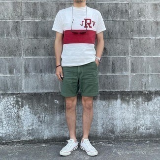 Dark Green Shorts Outfits For Men: Extremely dapper and practical, this combination of a white and red print crew-neck t-shirt and dark green shorts will provide you with amazing styling possibilities. White canvas low top sneakers integrate seamlessly within a multitude of ensembles.