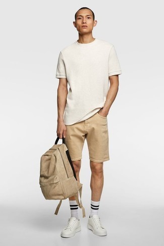 Beige Canvas Backpack Outfits For Men: You'll be amazed at how very easy it is for any gentleman to pull together a relaxed ensemble like this. Just a white crew-neck t-shirt worn with a beige canvas backpack. Introduce white leather low top sneakers to the mix to instantly shake up the look.