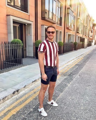 White Vertical Striped Crew-neck T-shirt Outfits For Men: This edgy pairing of a white vertical striped crew-neck t-shirt and navy shorts can take on different nuances depending on how it's styled. Look at how great this look is complemented with white print leather low top sneakers.