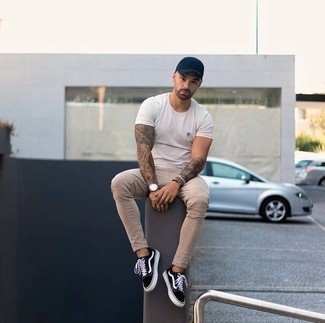 Beige Skinny Jeans Outfits For Men: For an on-trend ensemble without the need to sacrifice on functionality, we love this pairing of a white crew-neck t-shirt and beige skinny jeans. Unimpressed with this outfit? Invite black and white canvas low top sneakers to mix things up a bit.