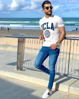White and Navy Print Crew-neck T-shirt Outfits For Men: Pair a white and navy print crew-neck t-shirt with blue ripped skinny jeans for a fashionable and easy-going outfit. Unimpressed with this ensemble? Introduce white print leather low top sneakers to change things up a bit.