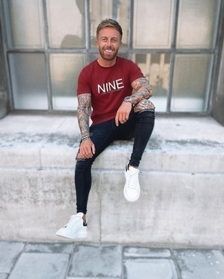 Burgundy Print Crew-neck T-shirt Outfits For Men: If it's comfort and functionality that you appreciate in an ensemble, team a burgundy print crew-neck t-shirt with black ripped skinny jeans. White and black leather low top sneakers will contrast beautifully against the rest of the look.