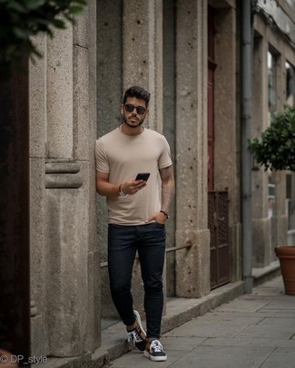 Navy Skinny Jeans Hot Weather Outfits For Men: A beige crew-neck t-shirt and navy skinny jeans are a smart getup worth having in your casual repertoire. Inject an added dose of elegance into your look by finishing off with a pair of black print canvas low top sneakers.