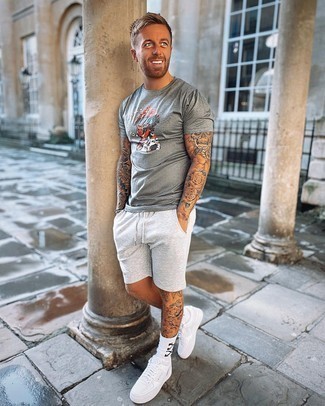 Grey Sports Shorts Outfits For Men: For a laid-back and cool outfit, try teaming a grey print crew-neck t-shirt with grey sports shorts — these pieces work pretty good together. Complete this outfit with white leather low top sneakers to immediately bump up the classy factor of this ensemble.