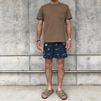 500+ Relaxed Hot Weather Outfits For Men: This combo of a brown crew-neck t-shirt and navy print sports shorts is extremely easy to pull together and so comfortable to work all day long as well! Want to play it down on the shoe front? Complete your getup with a pair of brown suede sandals for the day.