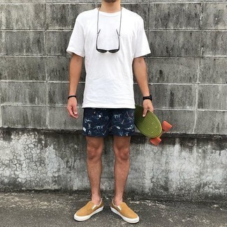 Beige Canvas Slip-on Sneakers Outfits For Men: Marrying a white crew-neck t-shirt and navy print sports shorts will hallmark your skills in men's fashion even on weekend days. Got bored with this ensemble? Enter a pair of beige canvas slip-on sneakers to switch things up.