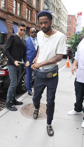 Lakeith Stanfield wearing White Crew-neck T-shirt, Navy Sweatpants, Black Embroidered Leather Loafers, Navy Fanny Pack