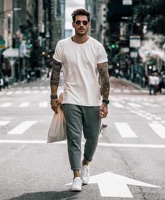 Olive Sweatpants Outfits For Men: The styling capabilities of a white crew-neck t-shirt and olive sweatpants ensure you'll always have them on high rotation. Go off the beaten path and break up your look by wearing a pair of white canvas low top sneakers.
