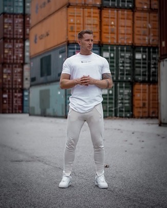 Tan Sweatpants Outfits For Men: Pair a white print crew-neck t-shirt with tan sweatpants for an easy-to-style getup. For a trendy hi-low mix, complete this getup with a pair of white leather low top sneakers.