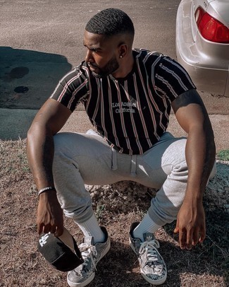 White and Navy Leather Low Top Sneakers Outfits For Men: To pull together an off-duty outfit with a contemporary spin, pair a black vertical striped crew-neck t-shirt with grey sweatpants. Introduce a pair of white and navy leather low top sneakers to the mix for an extra dose of style.