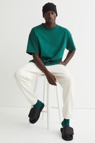 Dark Green Crew-neck T-shirt Outfits For Men: A dark green crew-neck t-shirt and white sweatpants will add serious cool to your off-duty wardrobe. Go ahead and complement this look with black canvas sandals for a sense of stylish casualness.