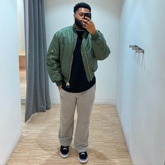Olive Nylon Bomber Jacket Outfits For Men: This combination of an olive nylon bomber jacket and grey sweatpants offers comfort and practicality and helps you keep it clean yet current. Black suede low top sneakers work wonderfully well within this outfit.