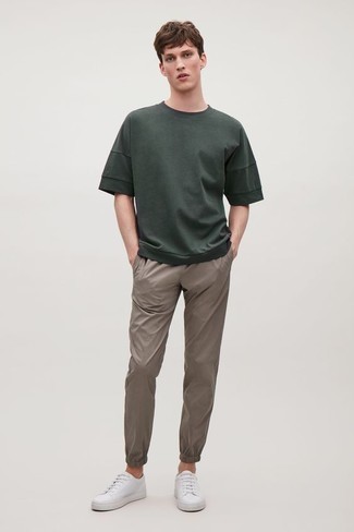 Dark Green Crew-neck T-shirt Outfits For Men: Combining a dark green crew-neck t-shirt with khaki chinos is an on-point choice for a cool and casual ensemble. Look at how nice this outfit is complemented with white leather low top sneakers.