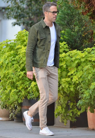 Olive Denim Jacket Outfits For Men: This combo of an olive denim jacket and beige chinos is solid proof that a straightforward casual ensemble doesn't have to be boring. White canvas low top sneakers will bring a more casual spin to an otherwise traditional outfit.