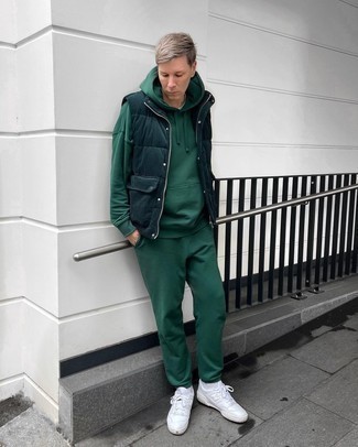 Dark Green Quilted Gilet Outfits For Men: Opt for a dark green quilted gilet and a dark green track suit if you want to look neat and relaxed without too much work. For something more on the smart side to finish off your look, complement your ensemble with white leather low top sneakers.