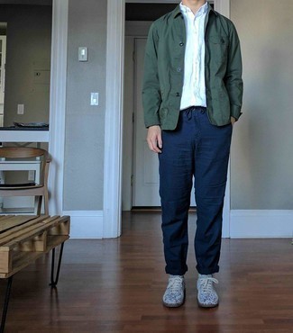 Grey Suede Low Top Sneakers Outfits For Men: This smart combination of a dark green shirt jacket and navy chinos can go different ways depending on the way you style it. A pair of grey suede low top sneakers can effortlessly play down an all-too-perfect outfit.