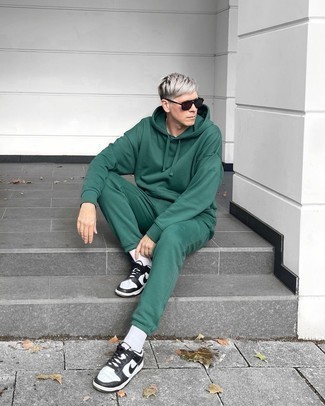 Black Sunglasses Outfits For Men: This bold casual combination of a dark green track suit and black sunglasses is extremely easy to pull together without a second thought, helping you look awesome and ready for anything without spending too much time digging through your wardrobe. To bring out a refined side of you, complement this ensemble with white and black leather low top sneakers.