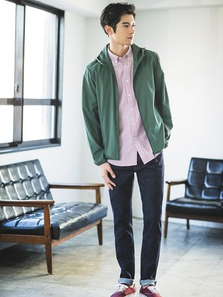Red Canvas Low Top Sneakers Outfits For Men: To achieve an off-duty look with a modern spin, choose a dark green windbreaker and navy jeans. The whole ensemble comes together if you introduce red canvas low top sneakers to this ensemble.