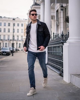 Beige Suede Low Top Sneakers Outfits For Men: You'll be surprised at how easy it is for any guy to get dressed this way. Just a black denim jacket matched with blue jeans. A great pair of beige suede low top sneakers ties this look together.