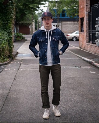 Blue Baseball Cap Outfits For Men: We all want practicality when it comes to fashion, and this bold casual combination of a navy denim jacket and a blue baseball cap is a great illustration of that. Here's how to dress it up: white canvas high top sneakers.