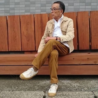 Beige Denim Jacket Outfits For Men: This off-duty combination of a beige denim jacket and tobacco chinos can go in different directions depending on the way you style it. To add a mellow vibe to this getup, add white canvas low top sneakers to your look.