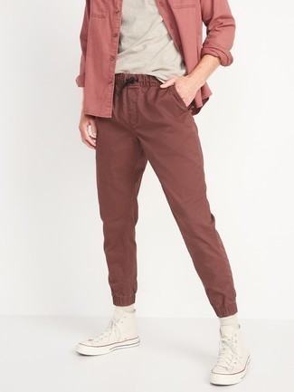 Pink Denim Shirt Outfits For Men: If you're searching for a casual but also dapper outfit, consider wearing a pink denim shirt and burgundy chinos. Send an otherwise traditional look in a more casual direction by rounding off with a pair of white canvas high top sneakers.