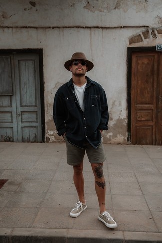 Shorts Outfits For Men: Such pieces as a navy denim shirt and shorts are an easy way to introduce effortless cool into your off-duty repertoire. Round off with tan canvas low top sneakers and ta-da: your outfit is complete.