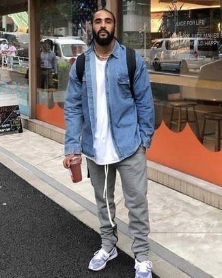 Black Canvas Backpack Outfits For Men: If you're obsessed with relaxed dressing when it comes to your personal style, you'll love this bold casual combo of a blue denim shirt and a black canvas backpack. All you need is a pair of light blue athletic shoes.