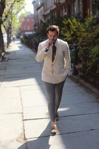 You'll be amazed at how easy it is for any guy to put together this effortlessly smart outfit. Just a beige double breasted blazer paired with grey chinos. Loosen things up and complement your look with a pair of brown leather boat shoes.