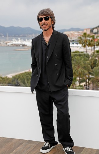 Pierpaolo Piccioli wearing Black Double Breasted Blazer, Black Long Sleeve Shirt, Black Dress Pants, Black and White Canvas Low Top Sneakers