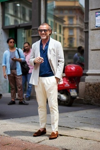 White Vertical Striped Double Breasted Blazer Outfits For Men: This pairing of a white vertical striped double breasted blazer and beige chinos will add masculine essence to your look. For an on-trend on and off-duty mix, go for a pair of brown suede tassel loafers.