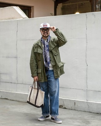 Beige Canvas Tote Bag Outfits For Men: Choose an olive field jacket and a beige canvas tote bag, if you feel like relaxed dressing but also like to look dapper. A trendy pair of navy print canvas slip-on sneakers is an effortless way to punch up your ensemble.