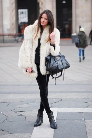 416 Winter Outfits For Women: A white fur coat and black skinny jeans are the kind of a no-brainer getup that you need when you have zero time. For extra fashion points, complement your ensemble with a pair of black leather ankle boots. If staying home snuggled up in a down comforter on a frosty winter day is not a possibility, this outfit will keep you cozy and absolutely chic from dawn till dusk.