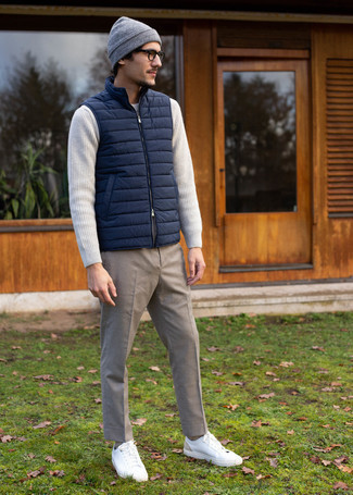 Grey Beanie Outfits For Men: A navy quilted gilet and a grey beanie are a laid-back pairing that every modern gentleman should have in his casual styling lineup. And if you want to immediately lift up this look with a pair of shoes, add white leather low top sneakers to the mix.