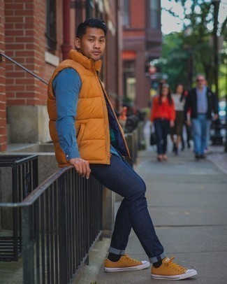 Mustard Quilted Gilet Outfits For Men: You're looking at the undeniable proof that a mustard quilted gilet and navy jeans look awesome when you team them up in a casual outfit. If you're wondering how to finish, complement this outfit with orange canvas low top sneakers.