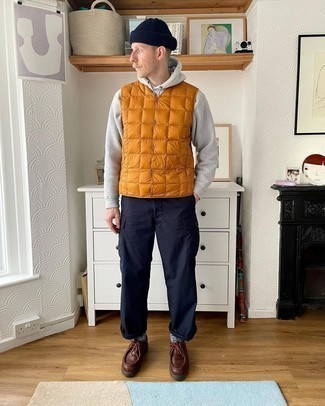 Navy Cargo Pants Outfits: Make an orange quilted gilet and navy cargo pants your outfit choice to bring out the dapper in you. Let your sartorial credentials truly shine by finishing off your getup with a pair of dark brown leather desert boots.