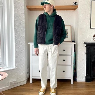 Green Baseball Cap Outfits For Men: To assemble a laid-back outfit with an urban spin, dress in a black fleece gilet and a green baseball cap. Feeling creative? Switch up your ensemble by wearing mustard canvas low top sneakers.