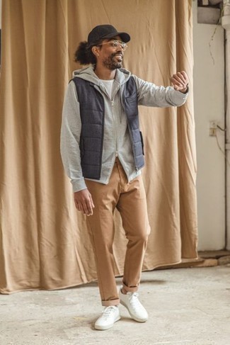 Blue Quilted Gilet Outfits For Men: A blue quilted gilet and khaki chinos are the kind of a foolproof off-duty combo that you so awfully need when you have zero time to put together an ensemble. A pair of white canvas low top sneakers can integrate effortlessly within a ton of outfits.