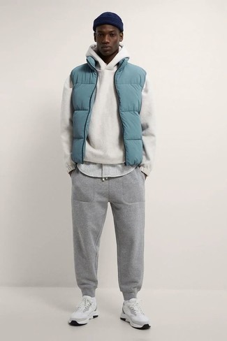 121 Relaxed Outfits For Men: Wear a light blue quilted gilet with grey sweatpants for a relaxed twist on day-to-day looks. In the footwear department, go for something on the laid-back end of the spectrum and complete this getup with white athletic shoes.