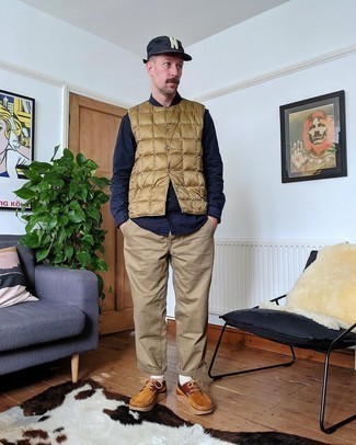 Tan Quilted Gilet Outfits For Men: Who said you can't make a fashion statement with a casual getup? You can do that easily in a tan quilted gilet and khaki chinos. Complement this ensemble with a pair of tobacco suede boat shoes and ta-da: this getup is complete.
