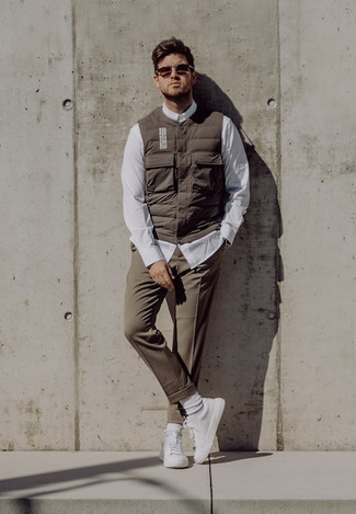 Brown Quilted Gilet Outfits For Men: For a look that's very straightforward but can be worn in a myriad of different ways, consider wearing a brown quilted gilet and brown chinos. Look at how great this ensemble pairs with white canvas low top sneakers.