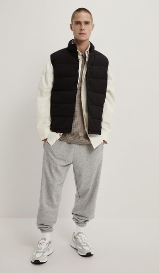 Black Quilted Gilet Outfits For Men: This pairing of a black quilted gilet and grey sweatpants combines comfort and efficiency and helps you keep it simple yet contemporary. Grey athletic shoes will bring a mellow vibe to an otherwise dressy getup.