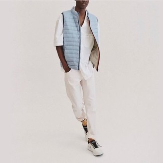 Light Blue Quilted Gilet Outfits For Men: Wear a light blue quilted gilet with white jeans for both seriously stylish and easy-to-style look. A good pair of white and black athletic shoes is the simplest way to bring a dash of stylish casualness to your getup.