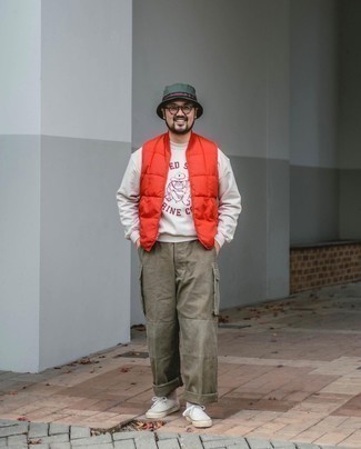 500+ Casual Outfits For Men: Parade your trendsetting side in a red quilted gilet and olive cargo pants. Let your outfit coordination expertise really shine by finishing off your outfit with a pair of white canvas low top sneakers.