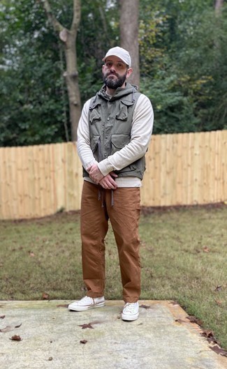 Olive Gilet Outfits For Men: For an outfit that's super easy but can be manipulated in many different ways, make an olive gilet and brown chinos your outfit choice. For times when this look is just too much, tone it down by slipping into white canvas low top sneakers.