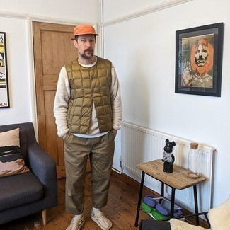 Yellow Baseball Cap Outfits For Men: Pair a brown quilted gilet with a yellow baseball cap for a relaxed ensemble with a city style finish. Inject this outfit with a dash of polish by sporting beige canvas slip-on sneakers.