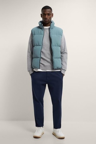 Light Blue Quilted Gilet Outfits For Men: Sharp yet comfy, this outfit combines a light blue quilted gilet and navy chinos. A pair of white canvas low top sneakers is a good choice to complement this getup.