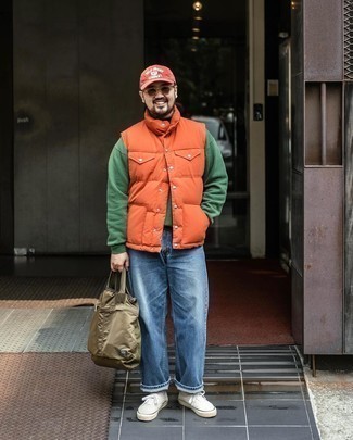 Orange Gilet Outfits For Men: This relaxed casual pairing of an orange gilet and blue jeans is very easy to throw together without a second thought, helping you look amazing and ready for anything without spending a ton of time searching through your closet. Add a pair of white canvas low top sneakers to this look et voila, your ensemble is complete.