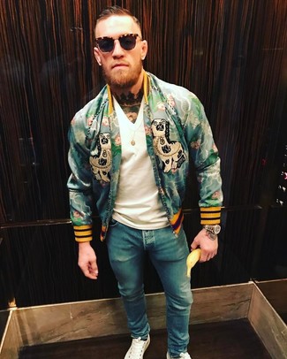 Conor McGregor wearing Green Print Bomber Jacket, White V-neck T-shirt, Blue Skinny Jeans, White Leather Low Top Sneakers
