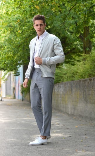 Grey Bomber Jacket Outfits For Men: Irrefutable proof that a grey bomber jacket and grey dress pants are awesome when married together in a polished look for a modern dandy. White leather derby shoes are a welcome addition to your outfit.